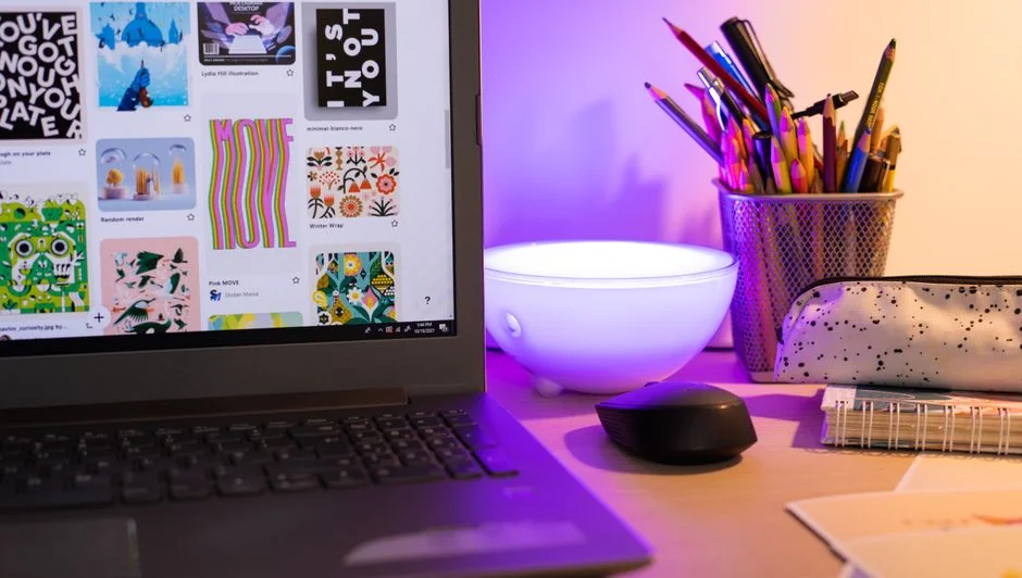 A lively work area with a laptop, tablet, and TV, brought to life by colorful lighting.